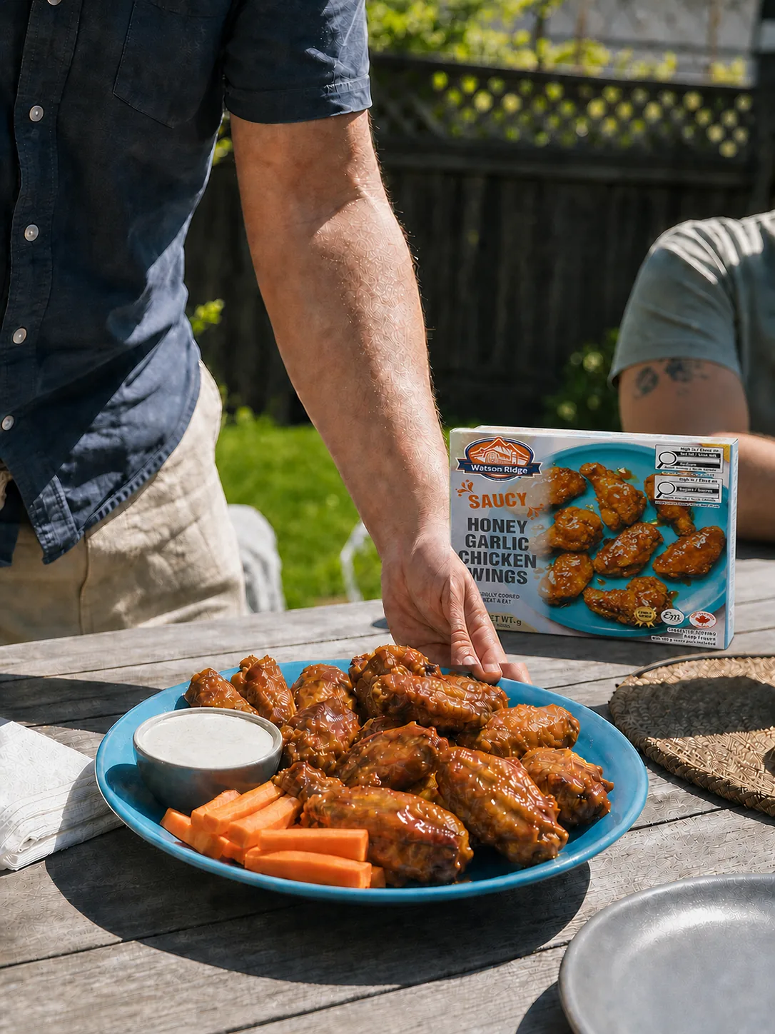 A platter of Watson Ridge honey garlic chicken wings being served at a backyard table